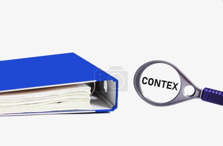 Foto de Contexto, imagen de concepto empresarial. En una lupa la palabra Contex sobre un fondo blanco con una carpeta azul. - Imagen libre de derechos