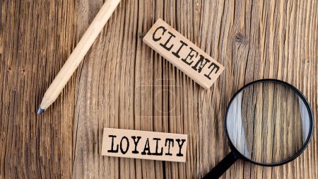 Photo for CLIENT LOYALTY words on a wooden building blocks on the wooden background - Royalty Free Image