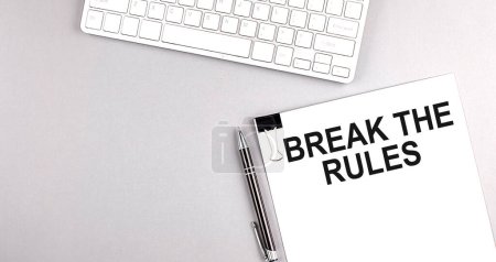 Téléchargez les photos : BREAK THE RULES texte sur un papier avec clavier sur fond gris - en image libre de droit