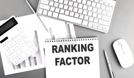 RANKING FACTOR text written on a notebook on grey background with chart and keyboard, business concept