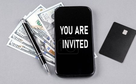 Téléchargez les photos : Carte de crédit et SMS VOUS ÊTES INVITÉ sur smartphone avec des dollars et un stylo. Entreprises - en image libre de droit