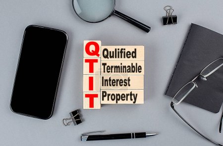 Photo for Wooden cubes QTIP Qualified Terminable Interest Property wtih notebook , magnifier and smartphone, business - Royalty Free Image