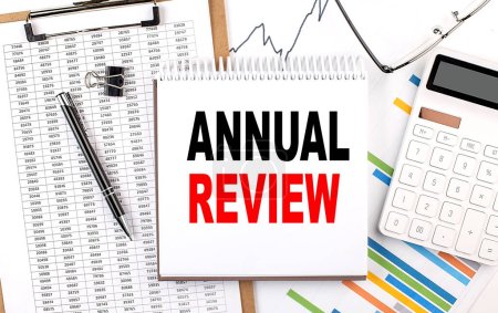 Photo for ANNUAL REVIEW text on a notebook with chart, calculator and pen - Royalty Free Image