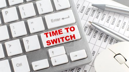 Foto de TIME TO SWITCH text on keyboard wirh chart and pencil - Imagen libre de derechos
