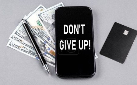Photo for Credit card and text DON T GIVE UP on a smartphone with dollars and pen. Business concept - Royalty Free Image