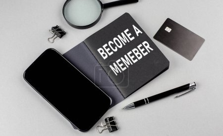 Photo for BECOME A MEMBER text written on a black notebook with smartphone, magnifier and credit card - Royalty Free Image