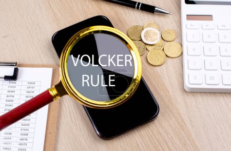 Foto de VOLCKER RULE text on magnifier with smartphone, calculator and coins - Imagen libre de derechos