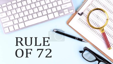 Téléchargez les photos : RULE OF 72 text on a blue background with keyboard and clipboard, business concept - en image libre de droit