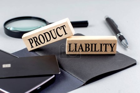 PRODUCT LIABILITY text on a wooden block on black notebook , business concept