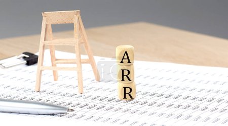 Foto de Cubos de madera con la palabra ARR soporte sobre fondo financiero, concepto de negocio. - Imagen libre de derechos