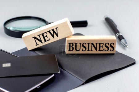 Téléchargez les photos : NEW BUSINESS text on a wooden block on black notebook , business concept - en image libre de droit