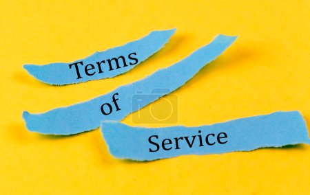 Téléchargez les photos : TERMS OF SERVICE text on blue pieces of paper on yellow background, business concept - en image libre de droit