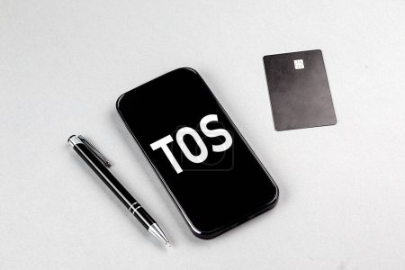 Foto de TOS - Términos de servicio palabra en un teléfono inteligente con tarjeta de crédito y pluma - Imagen libre de derechos