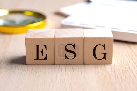Foto de ESG en cubos de madera con lupa y calculadora, fondo concepto financiero - Imagen libre de derechos