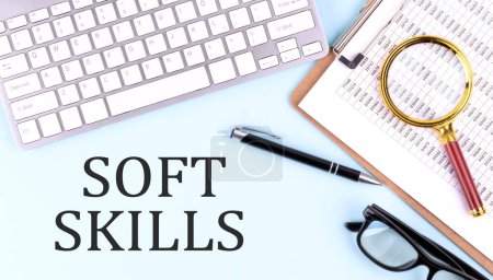 SOFT SKILLS text on a blue background with keyboard and clipboard, business concept
