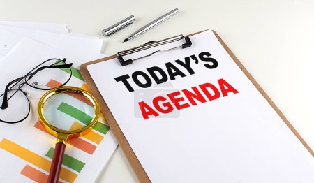 Photo for TODAY'S AGENDA text on a clipboard with chart on white background, business concept - Royalty Free Image