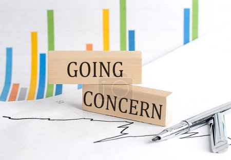 Photo for GOING CONCERN text on a notebook with pen and pencil on grey background - Royalty Free Image