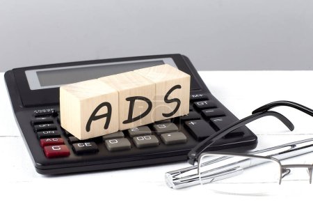 Téléchargez les photos : Concept ADS sur cubes en bois sur calculatrice sur fond blanc - en image libre de droit
