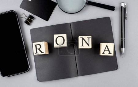 Photo for Word RONA on a wooden block on a black notebook with smartpone, credit card and magnifier - Royalty Free Image
