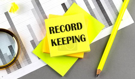 Photo for RECORD KEEPING text on a sticky on sticky on chart with pen - Royalty Free Image