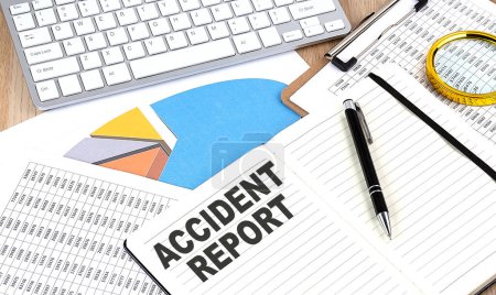 ACCIDENT REPORT text on a notebook with chart and keyboard