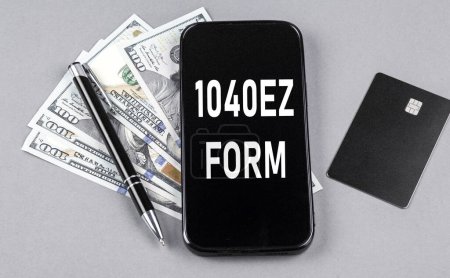 Téléchargez les photos : Carte de crédit et texte 1040 EZ FORM sur smartphone avec dollars et stylo. Concept d'entreprise - en image libre de droit