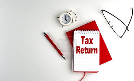 Photo for TAX RETURN text on a notebook , red pen and notebook, business concept, white background - Royalty Free Image
