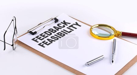 Photo for FEEDBACK FEASIBILITY text on a clipboard on white background, business concept - Royalty Free Image