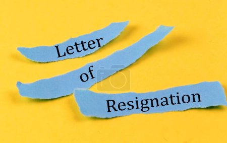 LETTER OF RESIGNATION text on blue pieces of paper on yellow background, business concept