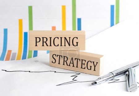 PRICING STRATEGY text on wooden block on chart background , business concept