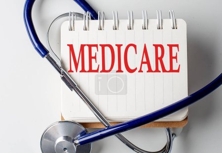 Medicare-Wort auf einem Notizbuch mit medizinischen Geräten im Hintergrund