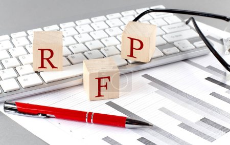 RFP written on wooden cube on the keyboard with chart on grey background