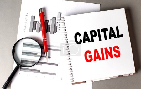 Photo for CAPITAL GAINS text written on a notebook with chart - Royalty Free Image