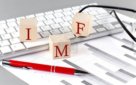 Téléchargez les photos : FMI écrit sur cube en bois sur le clavier avec graphique sur fond gris - en image libre de droit