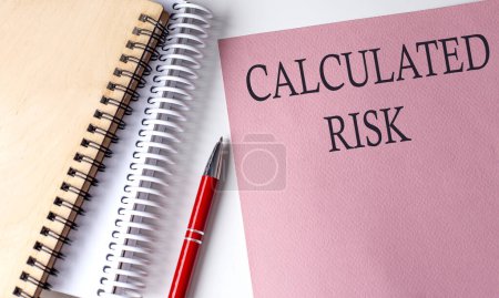 Photo for CALCULATED RISK word on pink paper with office tools on white background - Royalty Free Image