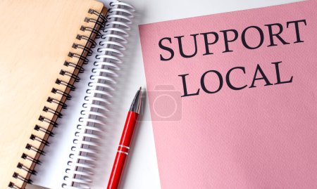 Téléchargez les photos : SUPPORT LOCAL mot sur papier rose avec des outils de bureau sur fond blanc - en image libre de droit