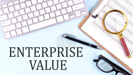 ENTERPRISE VALUE text on a blue background with keyboard and clipboard, business concept