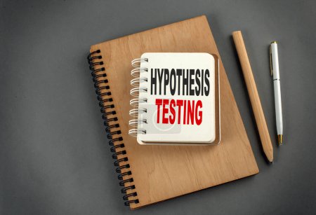 Photo for Hypothesis testing text on a notebook with pen and pencil on grey background - Royalty Free Image