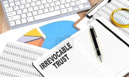 IRREVOCABLE TRUST text on a notebook with chart and keyboard
