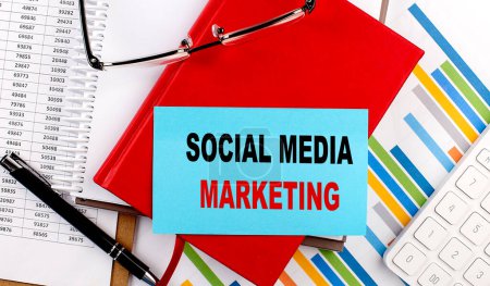 SOCIAL MEDIA MARKETING text on sticky on red notebook on chart background