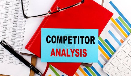 Photo for COMPETITOR ANALYSIS text on sticky on red notebook on chart background - Royalty Free Image