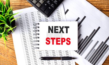 Photo for NEXT STEPS text on notebook with chart and calculator - Royalty Free Image