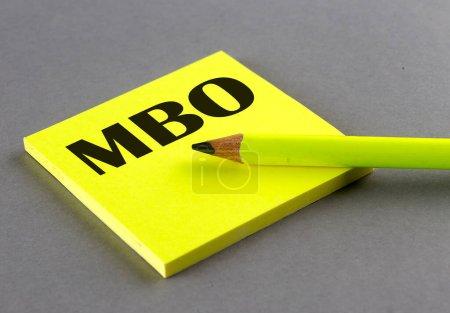 Téléchargez les photos : Texte MBO écrit sur fond collant sur fond gris - en image libre de droit