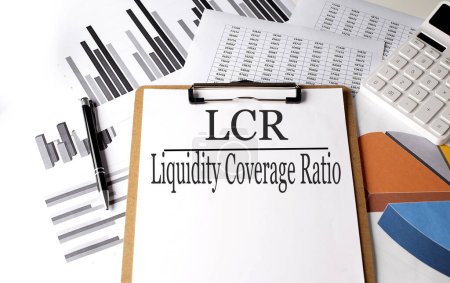 Téléchargez les photos : Papier avec LCR- LIQUIDITY COVERAGE RATIO sur fond de graphique, concept d'entreprise - en image libre de droit