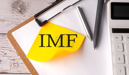 Téléchargez les photos : FMI mot sur un jaune collant avec calculatrice, stylo et presse-papiers - en image libre de droit