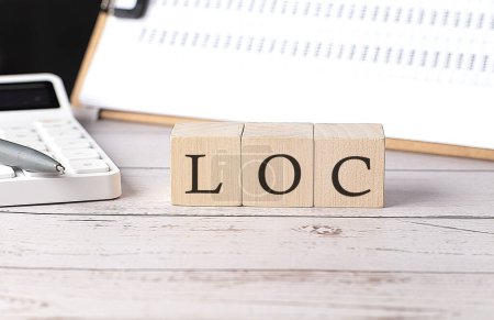 Foto de LOC palabra en bloque de madera con portapapeles y calcuador - Imagen libre de derechos