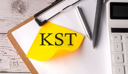 Téléchargez les photos : Mot KST sur jaune collant avec calculatrice, stylo et presse-papiers - en image libre de droit