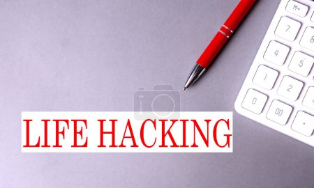 Photo for LIFE HACKING text written on gray background with pen and calculator - Royalty Free Image