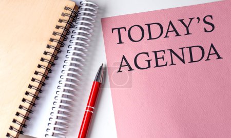 TODAY'S AGENDA word on pink paper with office tools on white background
