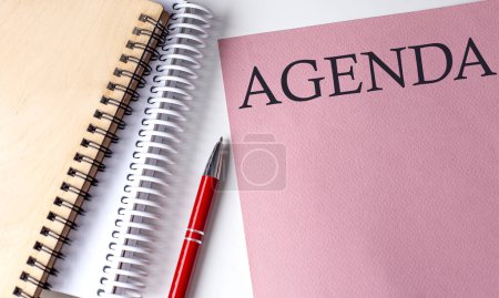 Photo for AGENDA word on pink paper with office tools on white background - Royalty Free Image